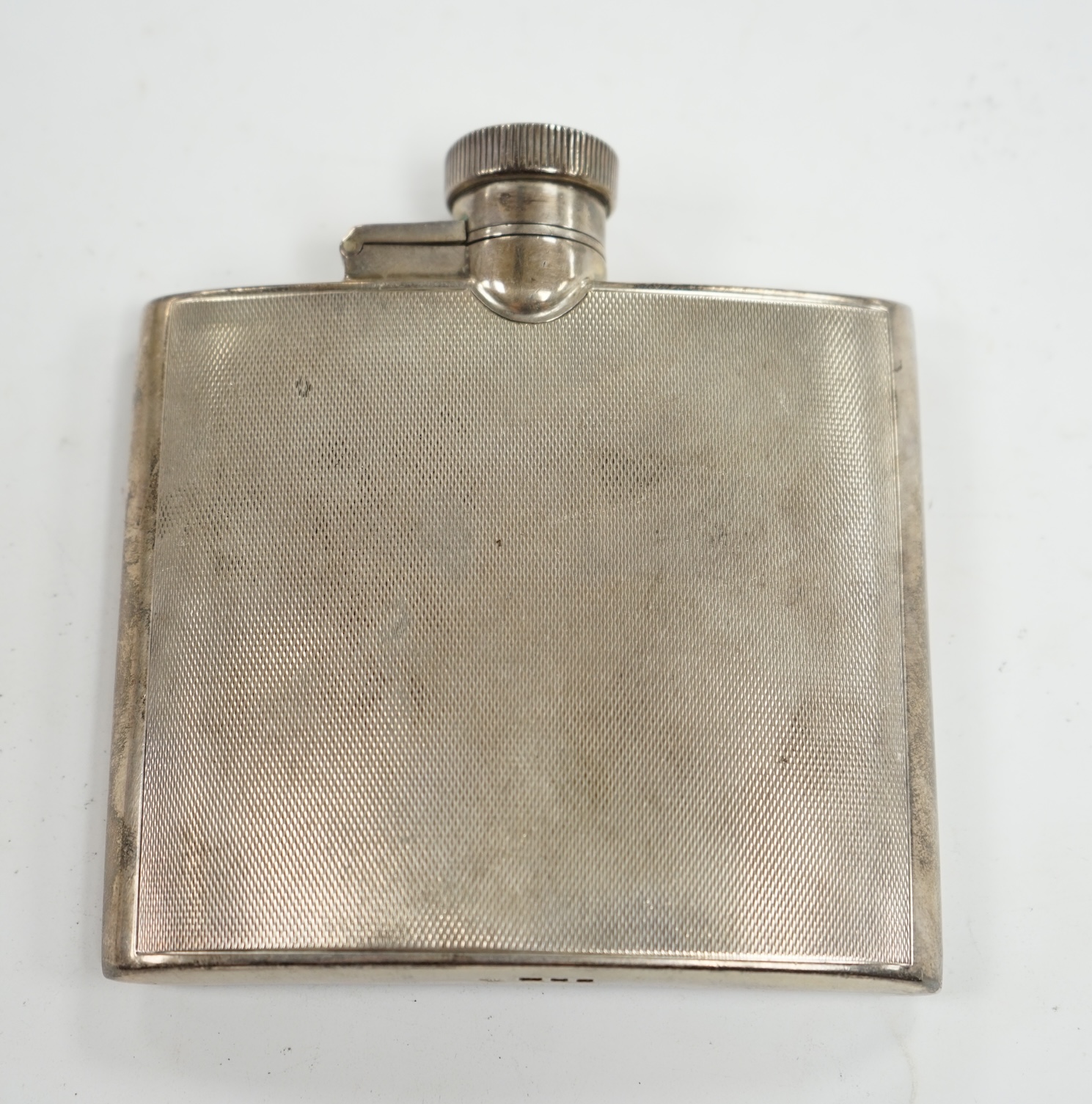 A George VI engine turned silver hip flask, Goldsmiths & Silversmiths Co Ltd, London, 1937, 95mm. Condition - fair